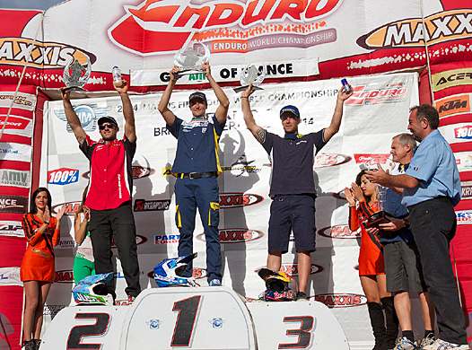 <i>Pierre-Alexandre Renet peut afficher son plus beau sourire (Alex Salvini 2e, Johnny Aubert 3e). Sacré Champion du Monde 2014 en catégorie E2 il y a quelques semaines, le Normand termine sa saison sur un nouveau succès en présence de Eric Simon (à droite), Président de la Commission d’Enduro et Rallyes Tout-Terrain (Photo : FFM).</i>